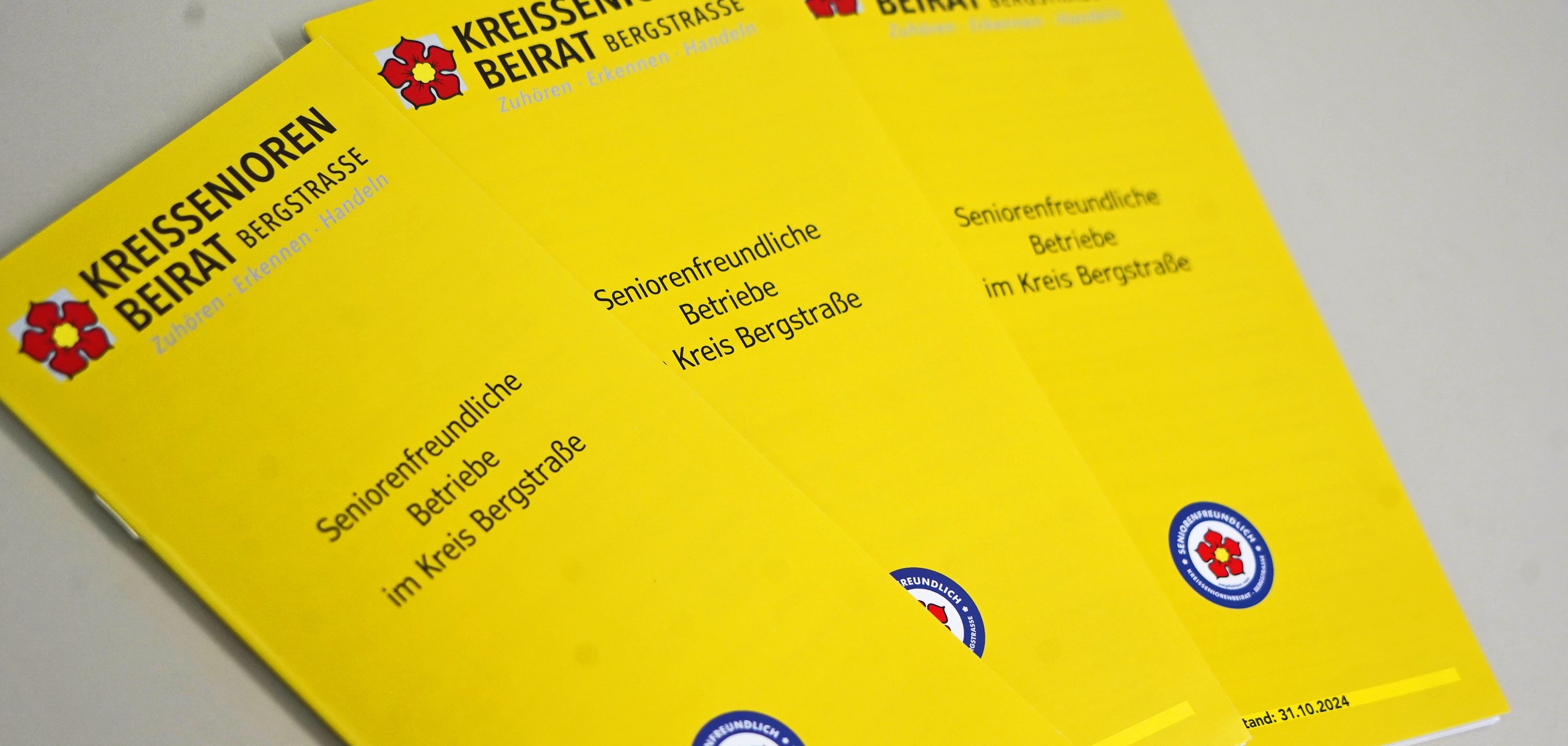 Drei Info-Broschüren mit der Aufschrift „Seniorenfreundliche Betriebe“ liegen nebeneeinander.