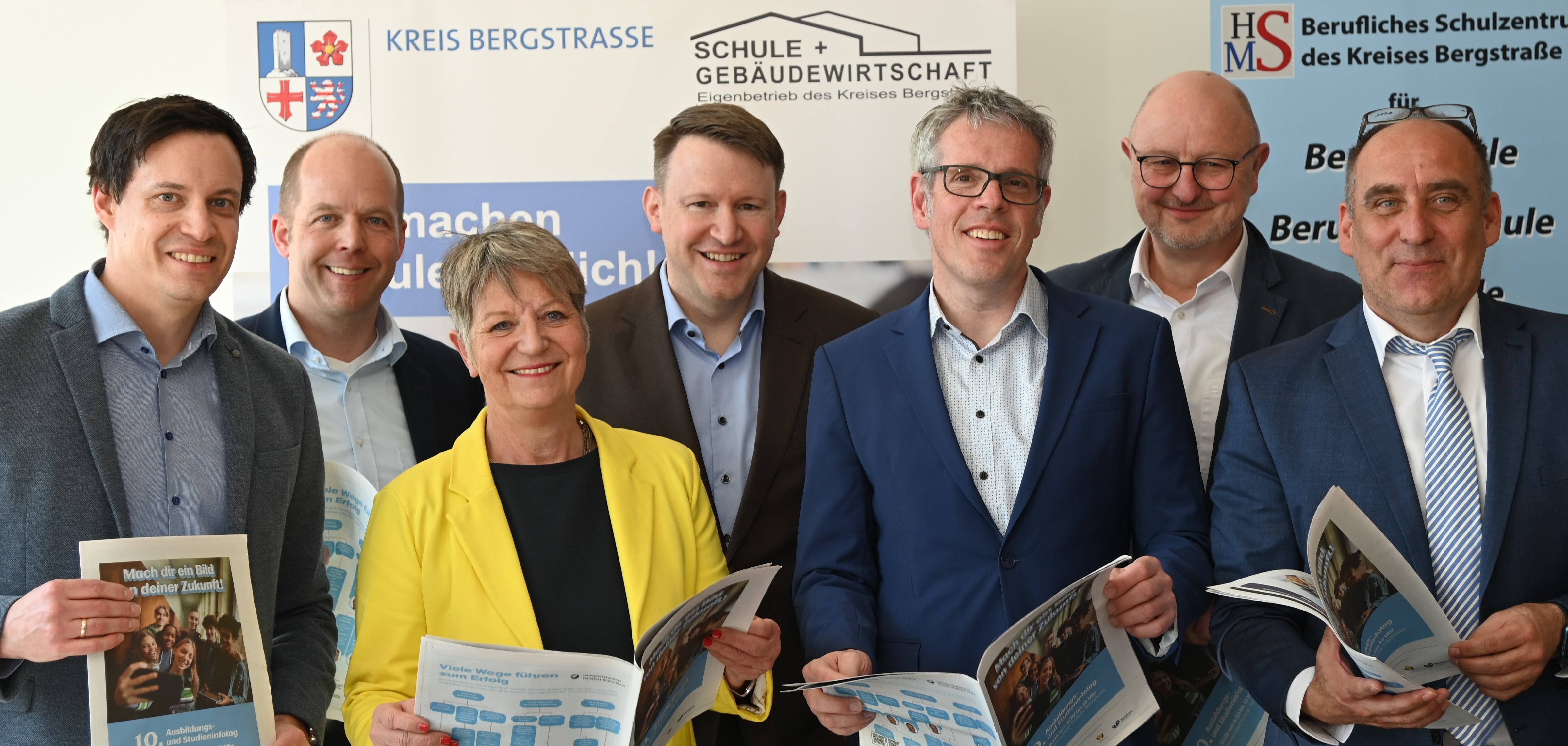 Der Kaufmännische Betriebsleiter Simon Menden, Geschäftsführer der Kreishandwerkerschaft Bergstraße Dietmar Schott, Bürgermeisterin Christine Klein, Geschäftsführer der Wirtschaftsförderung Bergstraße, Landrat Christian Engelhardt, Geschäftsführer der VhU Darmstadt und Südhessen und Schulleiter Thomas Bährer halten die druckfrische Sonderbeilage zum Ausbildungs- und Studieninfotag in den Händen.