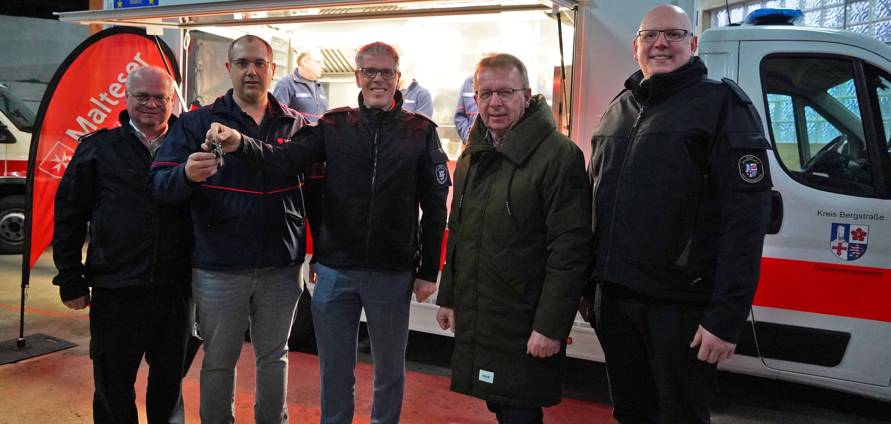 Landrat Christian Engelhardt steht gemeinsam mit dem Kreisbrandinspektor Steffen Lutter, Bürgermeister Matthias Baaß und dem stellvertretenden Kreisbrandinspektor Markus Stracke vor dem neuen Food-Truck des Malteser-Hilfsdienstes e.V. Viernheim.