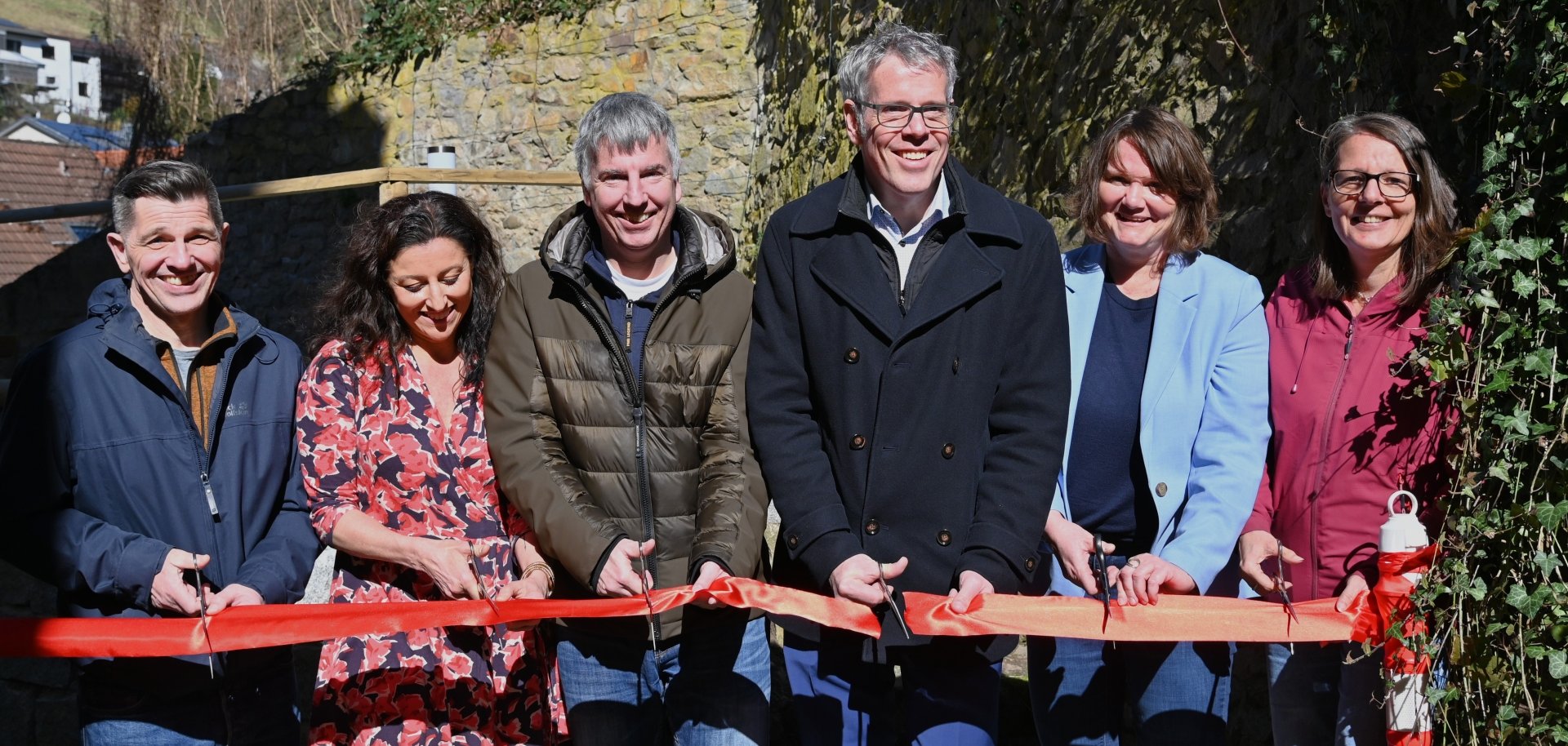 Ortsvorsteher Wolfgang Schlapp, die erste Vorsitzende des Förderervereins Freundeskreis der Christophorus-Schule Hambach, Inga Berg, der zweite Vorsitzende, Torsten Guthier, Landrat Christian Engelhardt, Schulleiterin Silke Massoth und die Erste Stadträtin Christine Bender zerschneiden gemeinsam das rote Band und geben damit das „Grüne Klassenzimmer“ offiziell für den Unterricht frei.