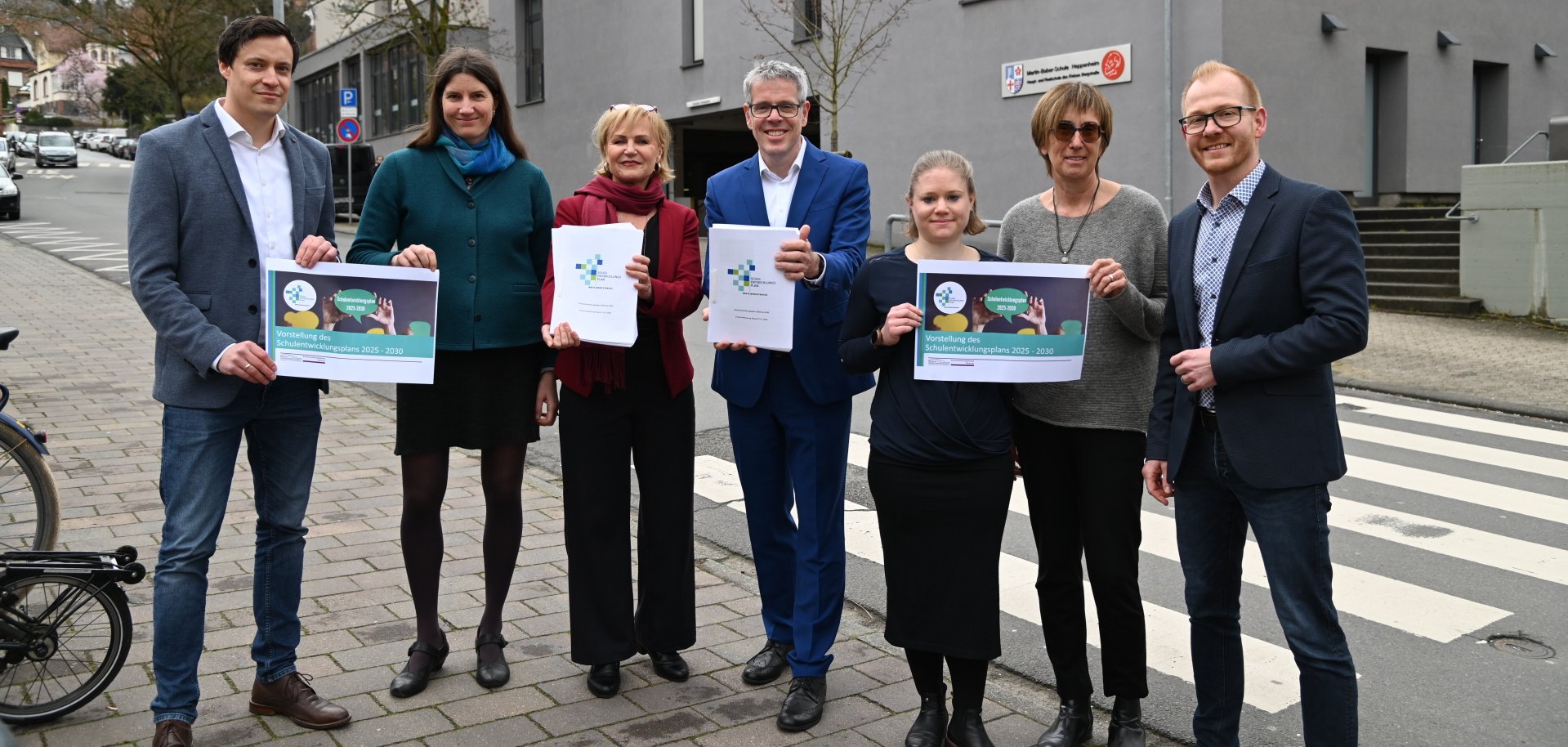 Vorstellung SEP Der kaufmännische Betriebsleiter, Simon Menden, die Beraterin für demografische Analysen und Schulentwicklungsplanung, Dr. Anja Reinermann-Matatko, Schulamtsleiterin Susann Hertz, Landrat Christian Engelhardt, das Schulentwicklungsteam mit Johanna Wolf und Claudia Blume sowie der technische Betriebsleiter des Eigenbetriebs Schule und Gebäudewirtschaft, Johannes Kühn, stehen vor dem Kreisgebäude und halten den Schulentwicklungsplan in den Händen.