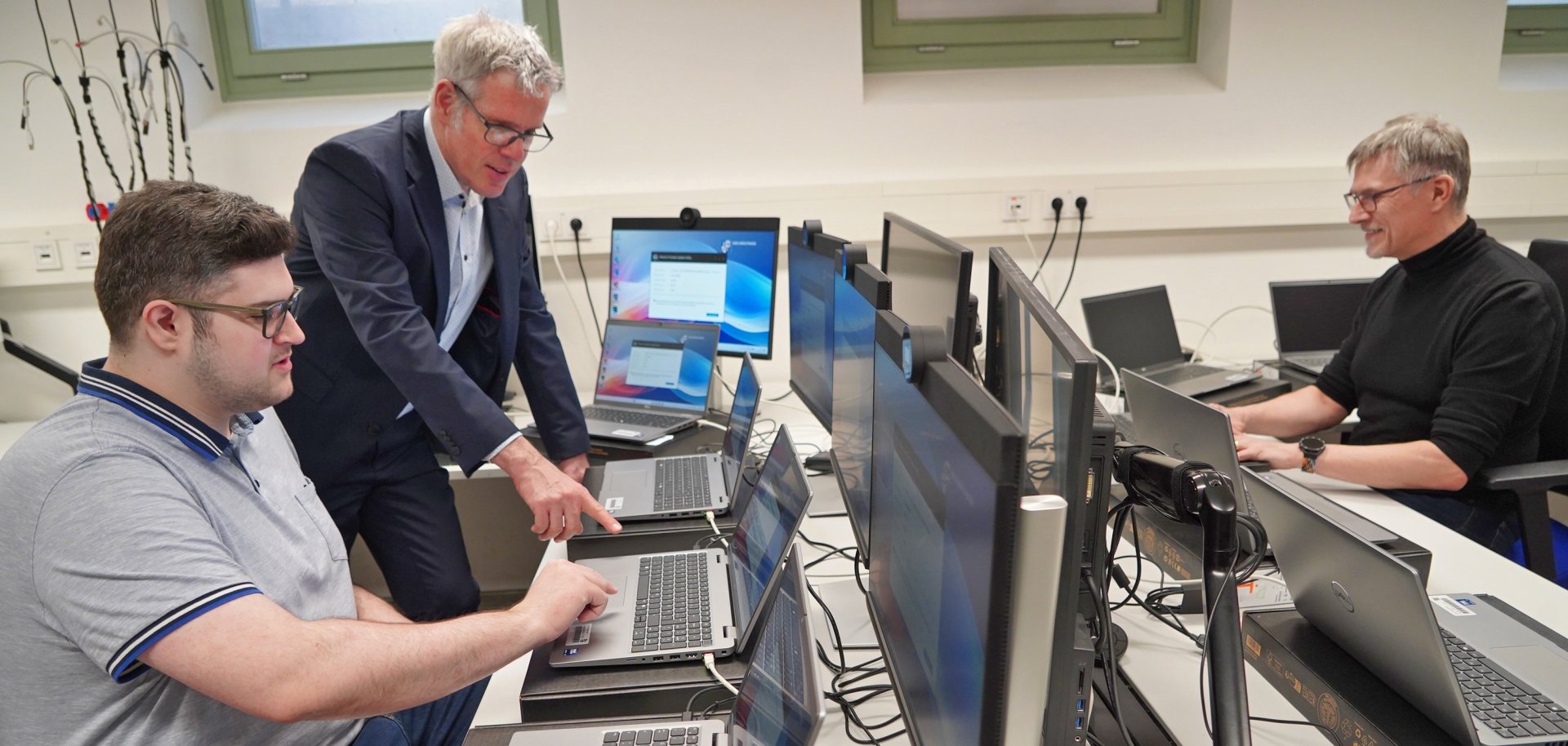 Landrat Christian Engelhardt lässt sich von den Mitarbeitern Lukas Lang und John Frederic Aris der Abteilung für Moderne Verwaltung, eGovernment und IT des Kreises den aktuellen Stand der mobilen Umstellung der Arbeitsplätze an einem Laptop zeigen.