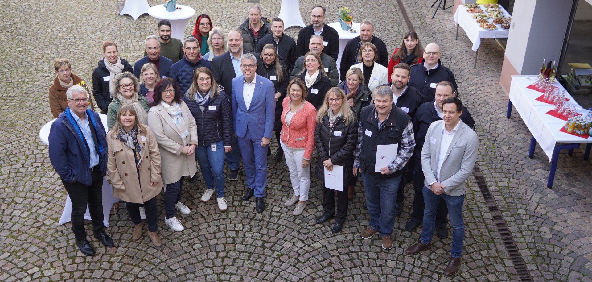 Landrat Christian Engelhardt steht gemeinsam mit einigen Mitarbeitenden im Innenhof des Landratsamtes. Alle schauen nach oben zur Kamera.