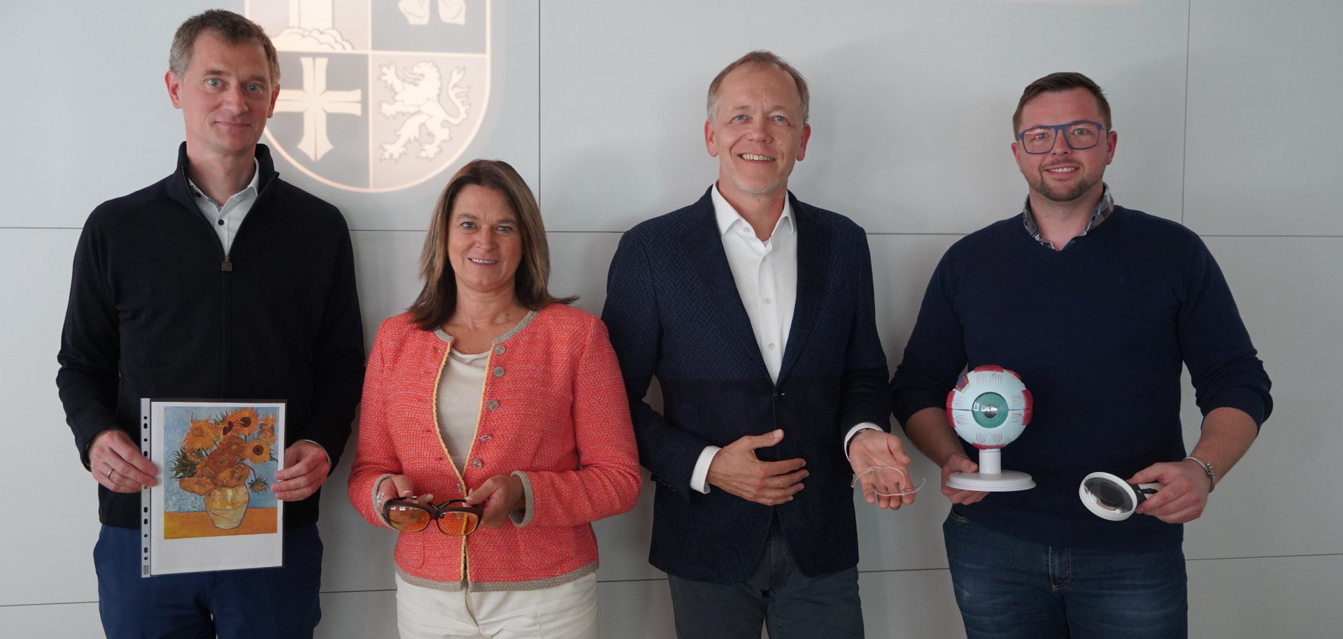 Die Erste Kreisbeigeordnete und Gesundheitsdezernentin Angelika Beckenbach steht mit dem Inhaber der Stadt-Apotheke, Dr. Oliver Sauer, dem Facharzt für Augenheilkunde, Dr. Josef Wolff sowie dem Optikermeister Martin Siekmann vor einer Wand mit der Aufschrift "Kreis Bergstraße" und halten Materialien zum Thema Augengesundheit in den Händen.