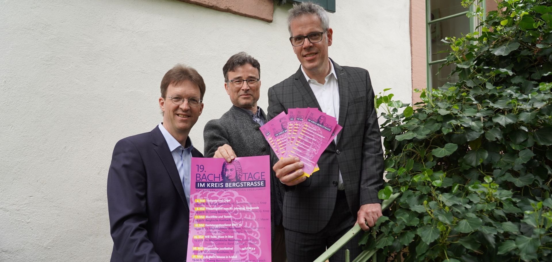 Landrat Christian Engelhardt (rechts) und zwei Organisatoren der Bachtage, Regionalkantor Gregor Knop (links) und Leiter des Oratorienchors Bergstraße, Christian Mause (Mitte) das Programm der diesjährigen Bachtage vor und halten Flyer in den Händen.