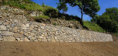 Ein Abschnitt der 51 Meter langen und bis zu zwei Meter hohen von Grund auf sanierten Trockenmauer auf dem Gelände.