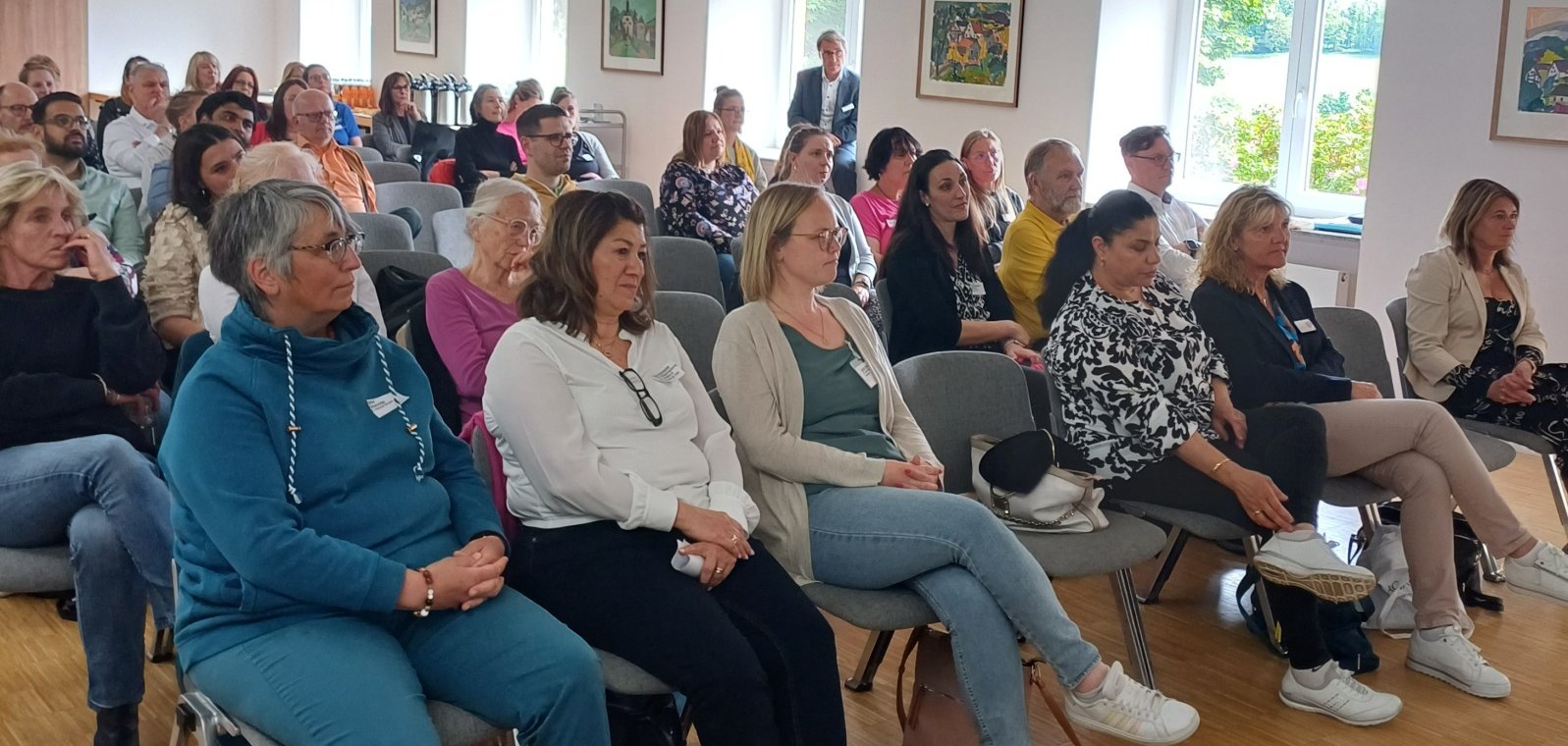 Die Teilnehmenden des Pflegetisches sitzen in einem Raum.