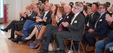 Zahlreiche Gäste sitzen bei der offiziellen Jubiläumsfeier im Bürgerhaus Mörlenbach im Publikum.