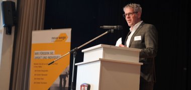 Landrat Christian Engelhardt steht auf der Bühne an einem Podium.