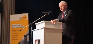 Der Hessische Ministerpräsidenten a.D., Prof. Dr. h.c. mult. Roland Koch steht auf der Bühne am Podium.