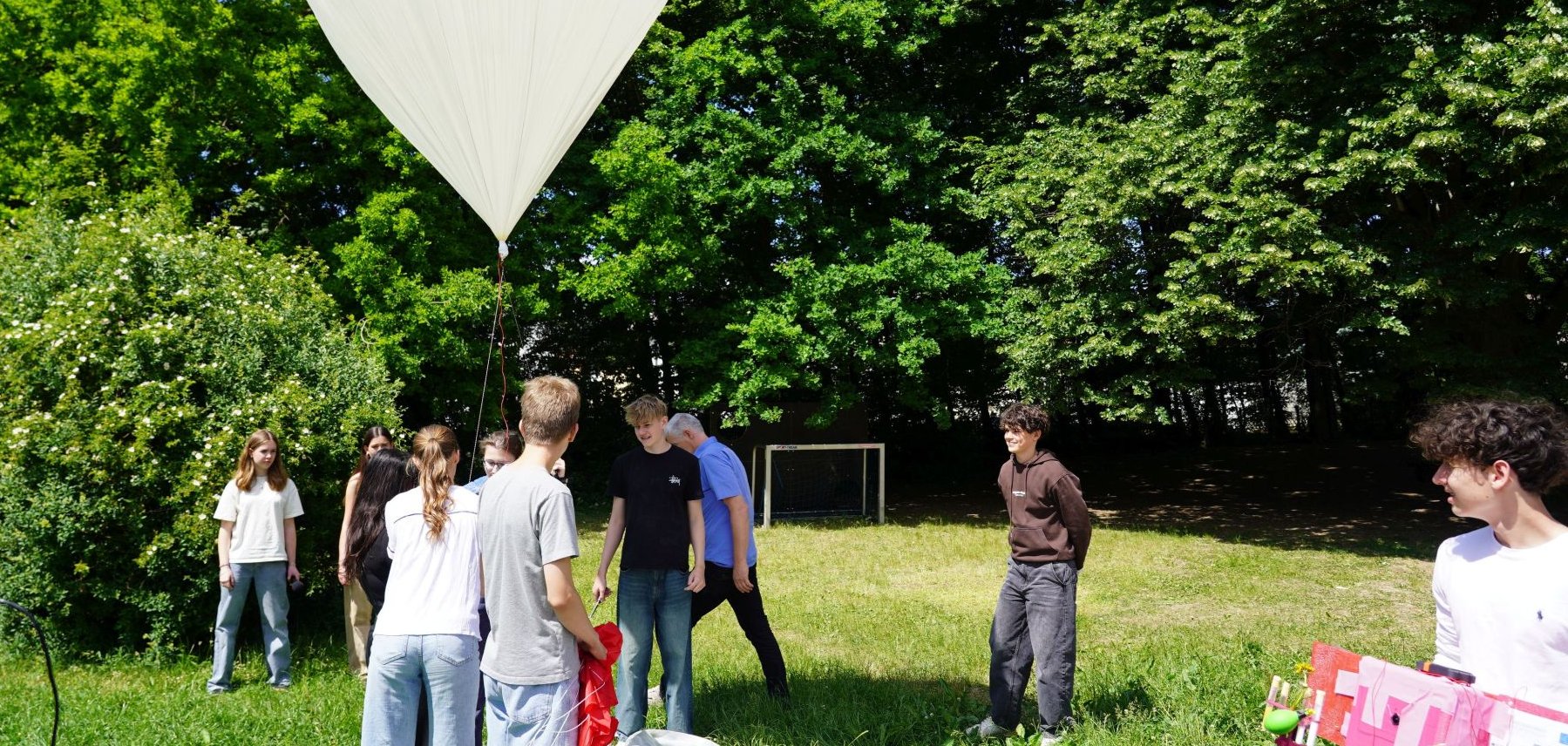 Aufbau des ersten Stratosphärenballons Die Schülerinnen und Schüler des Starkenburg-Gymnasiums bereiten zusammen mit dem Leiter des Forscherraums digi_space Jan Fuchs den Stratosphärenballon zum Abflug vor, indem sie ihn mit Helium auffüllen.