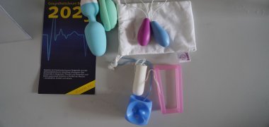 Hilfsmittel für das Beckenbodentraining Das Bild zeigt verschiedene Hilfsmittel für das Beckenbodentraining, wie einen blauen Würfel-Pessar sowie pinke und blaue tamponförmige Konen und einen Flyer zum Gesundheitsforum Bergstraße 2025.