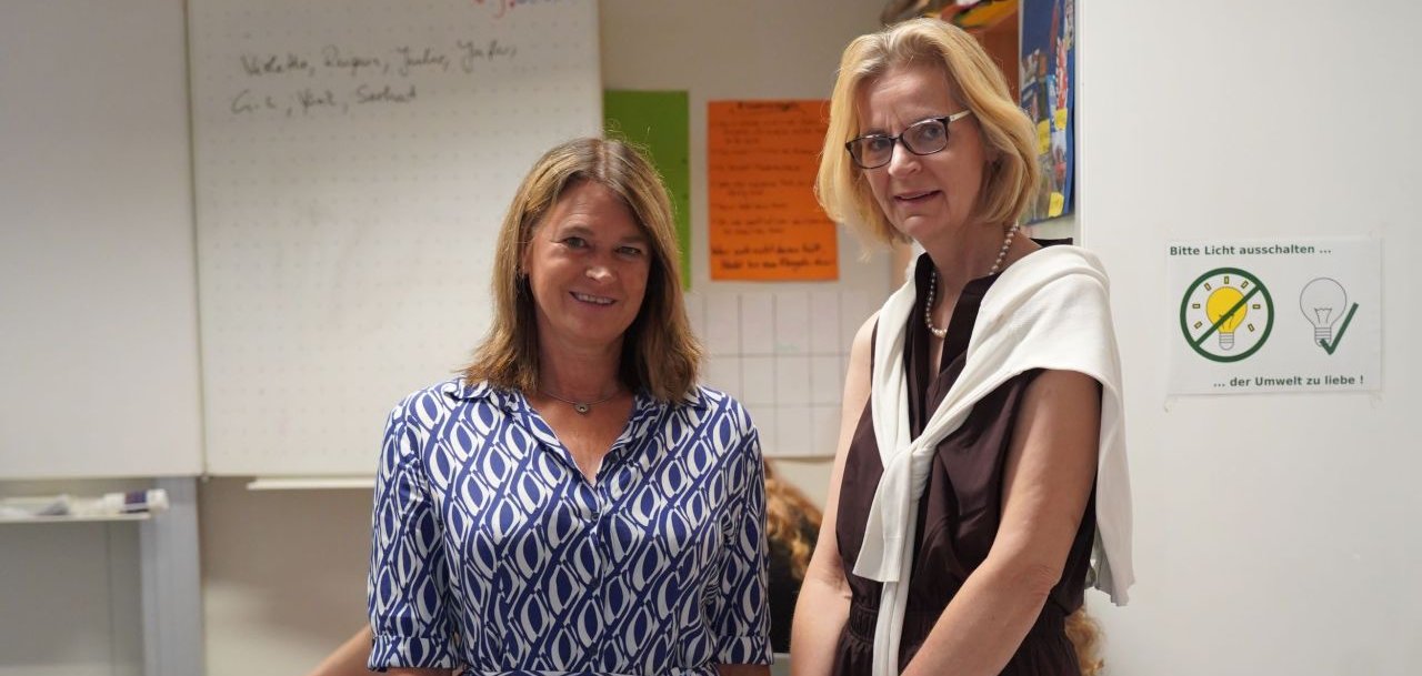 Die Erste Kreisbeigeordnete und Gesundheitsdezernentin Angelika Beckenbach (links) posiert zusammen mit der Schulleiterin Cornelia Schürer (rechts) in einem Klassenraum. 