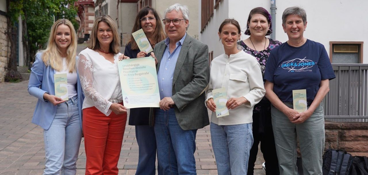 Die Erste Kreisbeigeordnete Angelika Beckenbach (2. v.l.) präsentiert zusammen mit den Mitarbeiterinnen und Mitarbeitern der Unabhängigen Beschwerdestelle (v.l.n.r.) Sophie Arnold (Vitos Klinik), Constantin von Gatterburg, Louisa Götzinger (Caritas), Verena Gaier (Psychiatrie-Erfahrene) und Lucia Raithel (Regionale Diakonie Bergstraße) sowie Kirstin Hörberg vom Fachbereich Soziale Dienste (3. v.l.) die neuen Flyer der Institution.