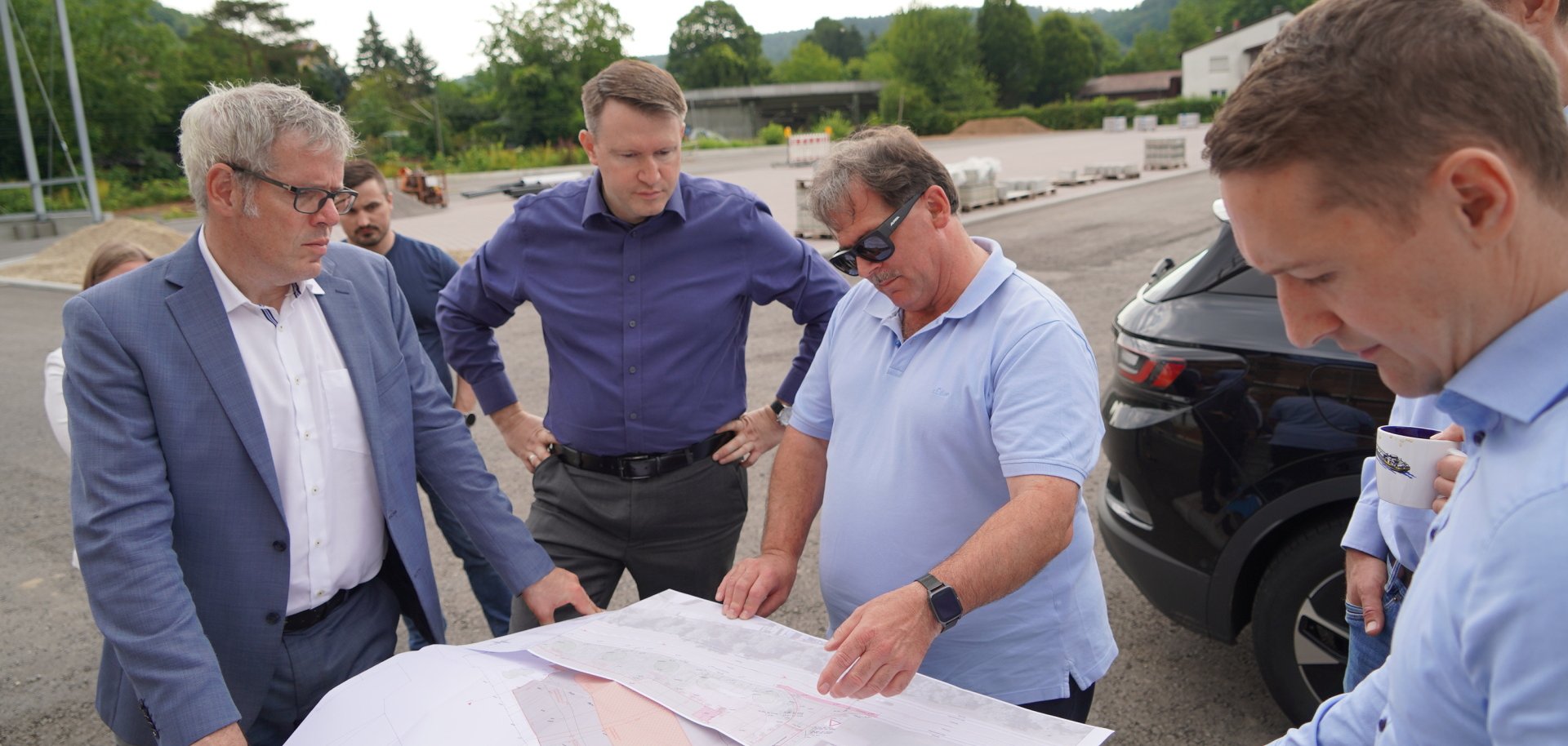 Landrat Christian Engelhardt und Dr. Matthias Zürker von der Wirtschaftsförderung Bergstraße schauen sich gemeinsam mit Daniel Außenhofer und Michael Krieger von der Heinrich Krieger und Söhne KG Baupläne an.