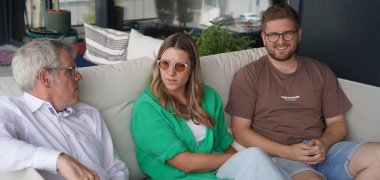 Landrat Engelhardt sitzt mit den Inhabern von Starts Design, Theresa Bartmann und Sebastian Theobald in Grasellenbach/Wahlen auf einer Couch.