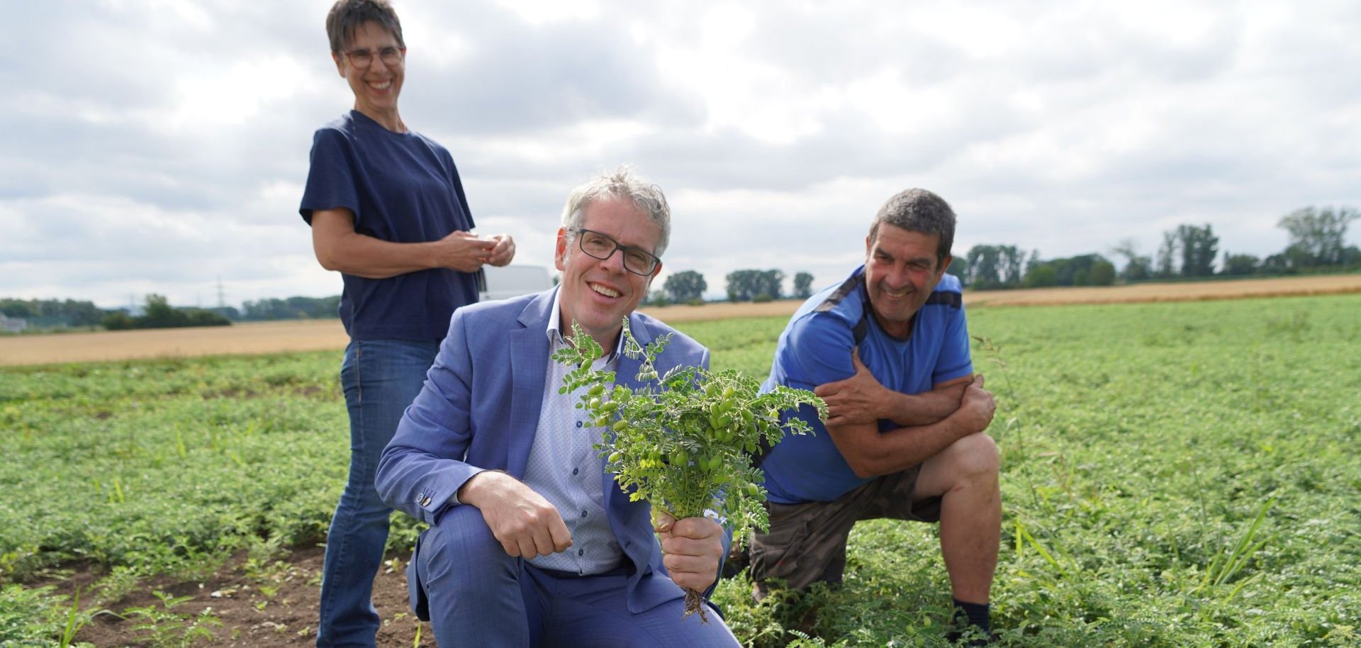 Landrat Christian Engelhardt (Mitte) ist mit dem Landwirte-Paar auf dem Feld und präsentiert die südhessische Kichererbse aus Biblis von Dagmar und Siegbert Ochsenschläger.