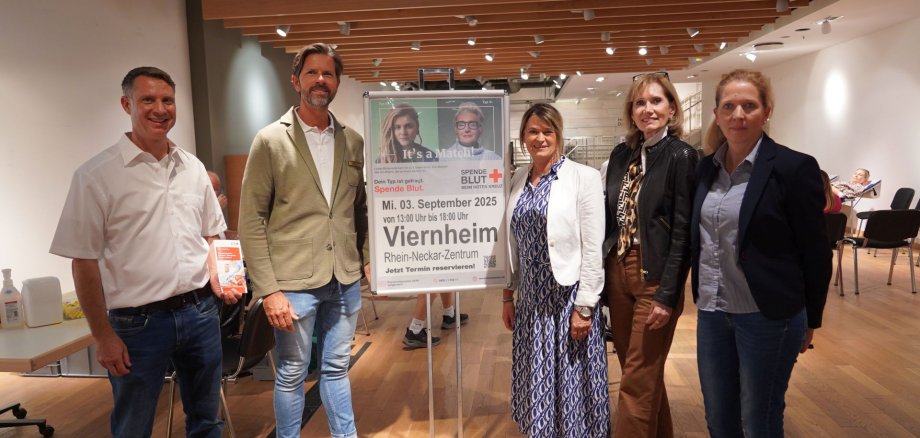 Auf dem Bild ist die Erste Kreisbeigeordnete und zuständige Dezernentin Angelika Beckenbach (3. v.r) gemeinsam mit dem Referent Spenderbindung des DRK-Blutspendedienstes Baden-Württemberg/Hessen Eric Max (links), dem Centermanager des Rhein-Neckar-Zentrums Dani Marquardt (2. v.l.) sowie Reinhild Zolg (2. v.r.) und Nadja Niestroj (rechts) vom Präventionsteam des Kreises Bergstraße zu sehen. Links neben ihr befindet sich ein großes Schild mit Eckdaten zum Termin.