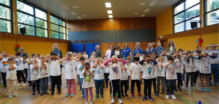 Die Grundschülerinnen und -schüler sind in der Sporthalle der Grundschule alle versammelt