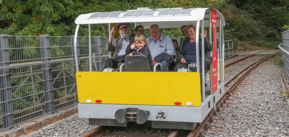 Eine Familie sitzt in der Solardraisinenbahn.