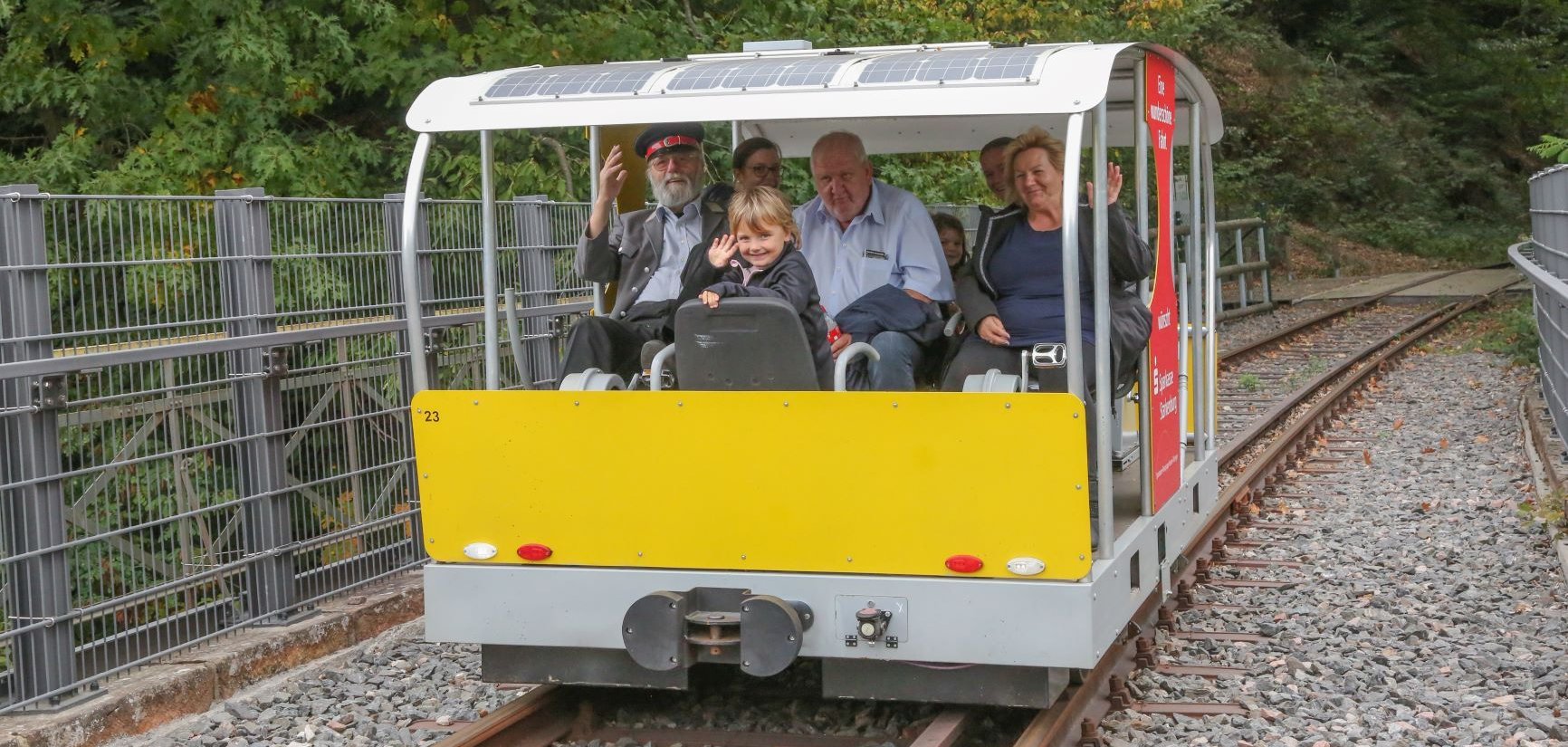 Eine Familie sitzt in der Solardraisinenbahn.