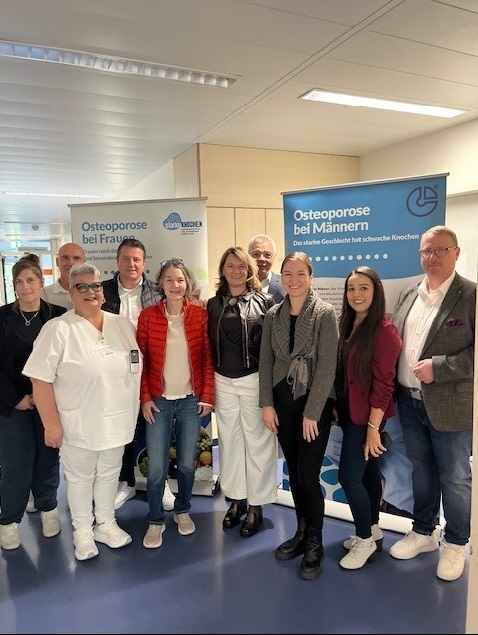 Die Erste Kreisbeigeordnete Angelika Beckenbach (Mitte) klärt zusammen mit (v.l.n.r.) Michaela Weber (PauLa NORIE), Irena Wolf (Leitung Geriatrische Tagesklinik des St. Marien Krankenhauses) in Begleitung von ihrem Mann, Alexander Scholl (designierter Bürgermeister von Lampertheim), Christina Adler-Schäfer (PauLa NORIE), Bürgermeister Gottfried Störmer, Jennifer Jarke (Fachbereichsleitung Gesundheitsversorgung des Gesundheitsamtes), Selina Werner-Celikkan (Referentin der Geschäftsführung des St. Marien Krankenhauses) und Florian Busse (Geschäftsführer des Krankenhauses) über die Knochenkrankheit auf.