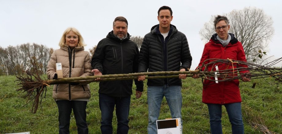 Ute Schollmaier von der Abteilung Ländlicher Raum der Kreisverwaltung Bergstraße, Florian Schumacher vom Gewässerverband Bergstraße, Simon Menden, Leiter der Abteilung Ländlicher Raum sowie Stefanie Seitz vom Landschaftspflegeverband Bergstraße e.V. mit einem Obstbaum in den Händen.