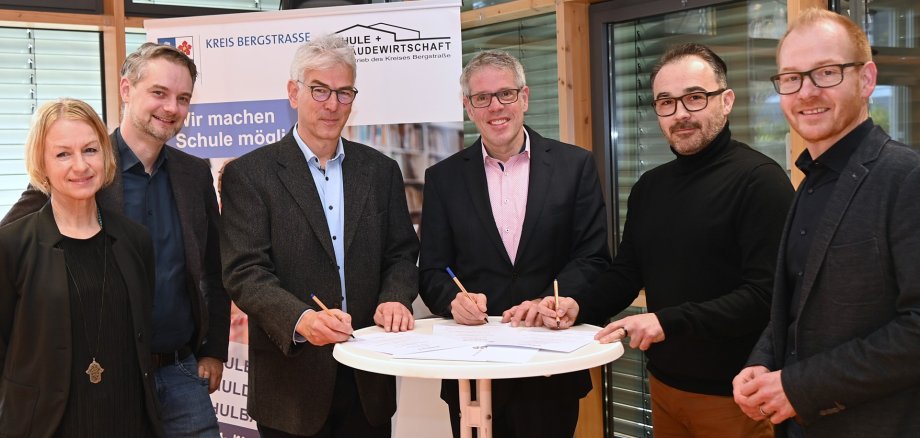 Barbara Ludwig vom Sachgebiet Schulverwaltung und -entwicklung des Eigenbetriebs Schule und Gebäudewirtschaft, Bürgermeister Lutz Spitzner, kommissarischer Schulleiter, Andreas Alferding-Kühn, Landrat Christian Engelhardt, Johannes Steigleder der Betreuungsträgers Purzel gGmbH und der Technische Betriebsleiter des Eigenbetriebs Schule und Gebäudewirtschaft, Johannes Kühn besiegeln den Pakt für den Ganztag mit ihrer Unterschrift.