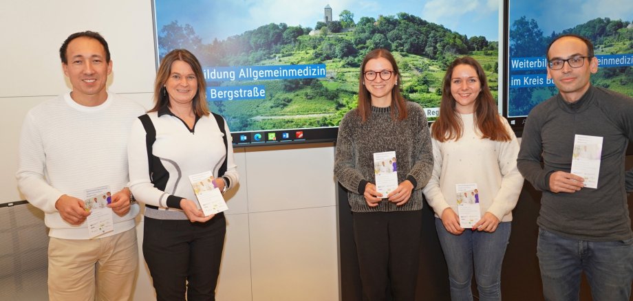 Vorstellung Webseite WBV Die erste Kreisbeigeordnete und Gesundheitsdezernentin Angelika Beckenbach steht gemeinsam mit dem Vorsitzenden des Weiterbildungsverbundes Allgemeinmedizin Bergstraße sowie leitenden Ärztlichen Direktor und Chefarzt der Kardiologie des Kreiskrankenhauses Bergstraße, Prof. Dr. Stefan Baumann, dem stellvertretenden Vorsitzenden und hausärztlich tätigen Facharzt für Innere Medizin, Dr. Florian Wagner, der Leiterin des Fachbereichs Gesundheitsversorgung des Kreises Bergstraße, Jennifer Jarke, sowie Sandra Schmitt vom Fachbereich Gesundheitsversorgung, vor einem Bildschirm mit der neuen Website.