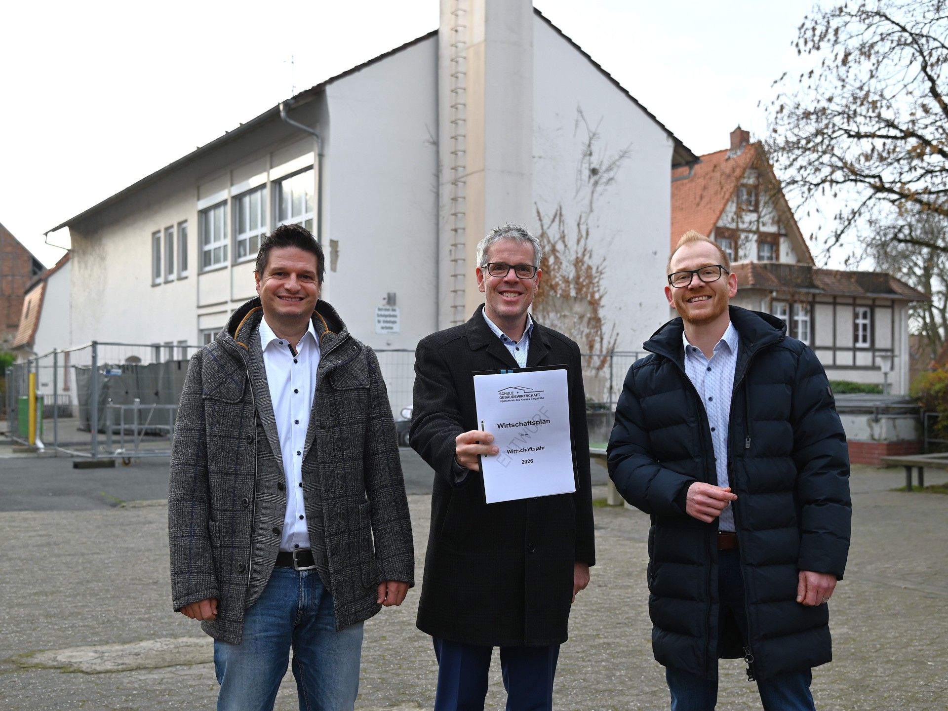 (v. l. n. r.) Der stellvertretende Kaufmännische Betriebsleiter des Eigenbetriebs Schule und Gebäudewirtschaft, Stefan Lienert, Landrat Christian Engelhardt und der Technische Betriebsleiter des Eigenbetriebs Schule und Gebäudewirtschaft, Johannes Kühn, präsentieren das Zahlenwerk (für die Kamera) direkt vor einem laufenden Projekt: dem Umbau der Martin-Buber-Schule in Heppenheim zur integrierten Gesamtschule.