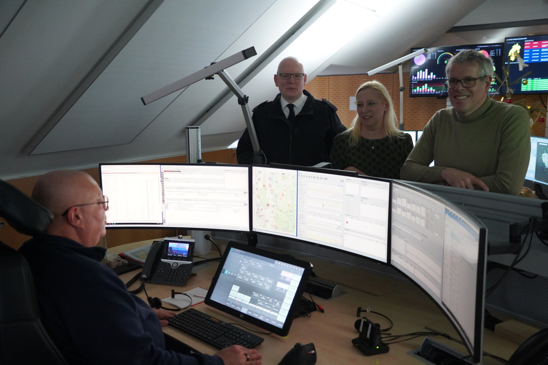Überbrachten symbolisch ein großes Dankeschön: Landrat Christian Engelhardt (re) und Diana Stolz (Hessische Ministerin für Familie, Senioren, Sport, Gesundheit und Pflege) in der Leitstelle des Kreises Bergstraße mit Markus Stracke und David Rosenfeld (links).