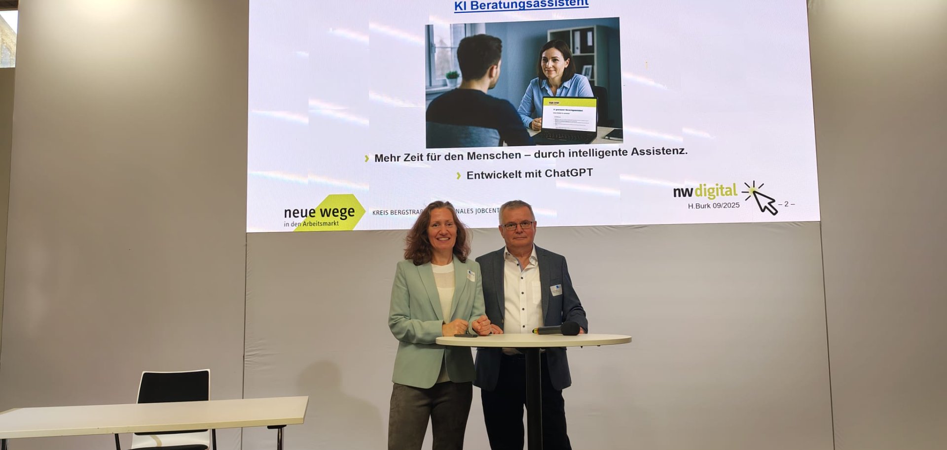 Neue Wege Chatbot Beim „Tag der kommunalen Jobcenter“ in Berlin stellen die Leiterin des Eigenbetriebs, Dr. Melanie Marysko, und Entwickler Helmut Burk den KI-gestützten Beratungsassistenten von Neue Wege Kreis Bergstraße vor.