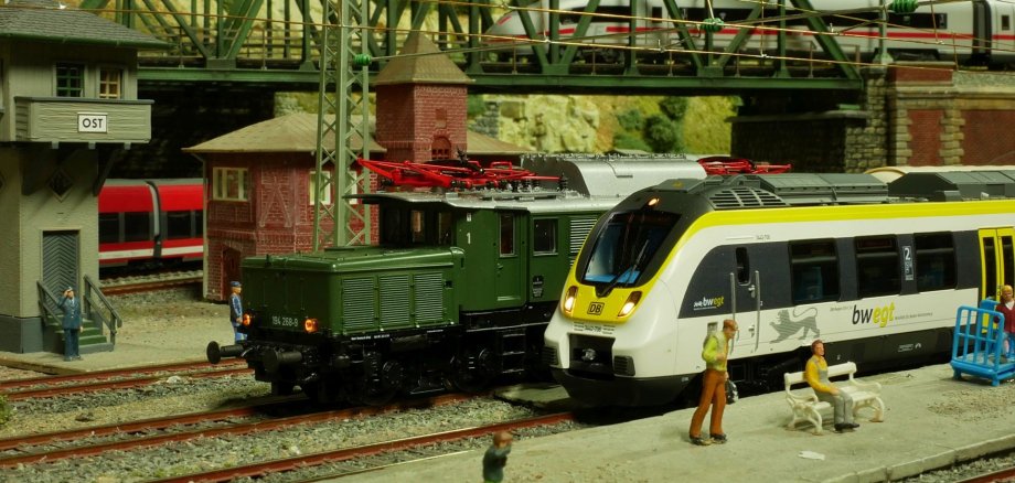 Fürther Miniaturwelten Das Bild zeigt einen Ausschnitt der Modellbahn mit zwei Zügen und kleinen Figuren.