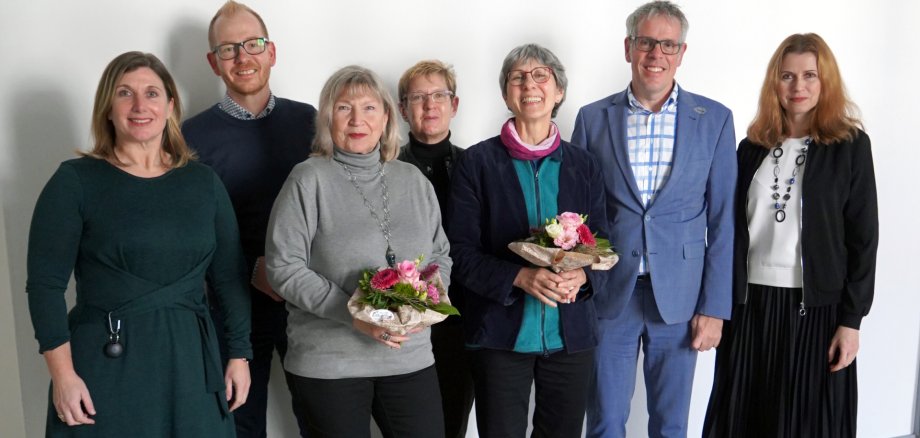 Landrat Christian Engelhardt, die Leiterin der Stabstelle Integrationsbeauftragte, Viktoriya Ordikhovska, der Technische Leiter des Eigenbetriebs Schule und Gebäudewirtschaft, Johannes Kühn, die Leiterin des Fachbereichs Personalmanagement, Sonja Seidl, und die Personalratsvorsitzende Sonja-Kröner-Mews stehen mit Monika Bauer-Herzog und Beate Pfündl vor einer weißen Wand.