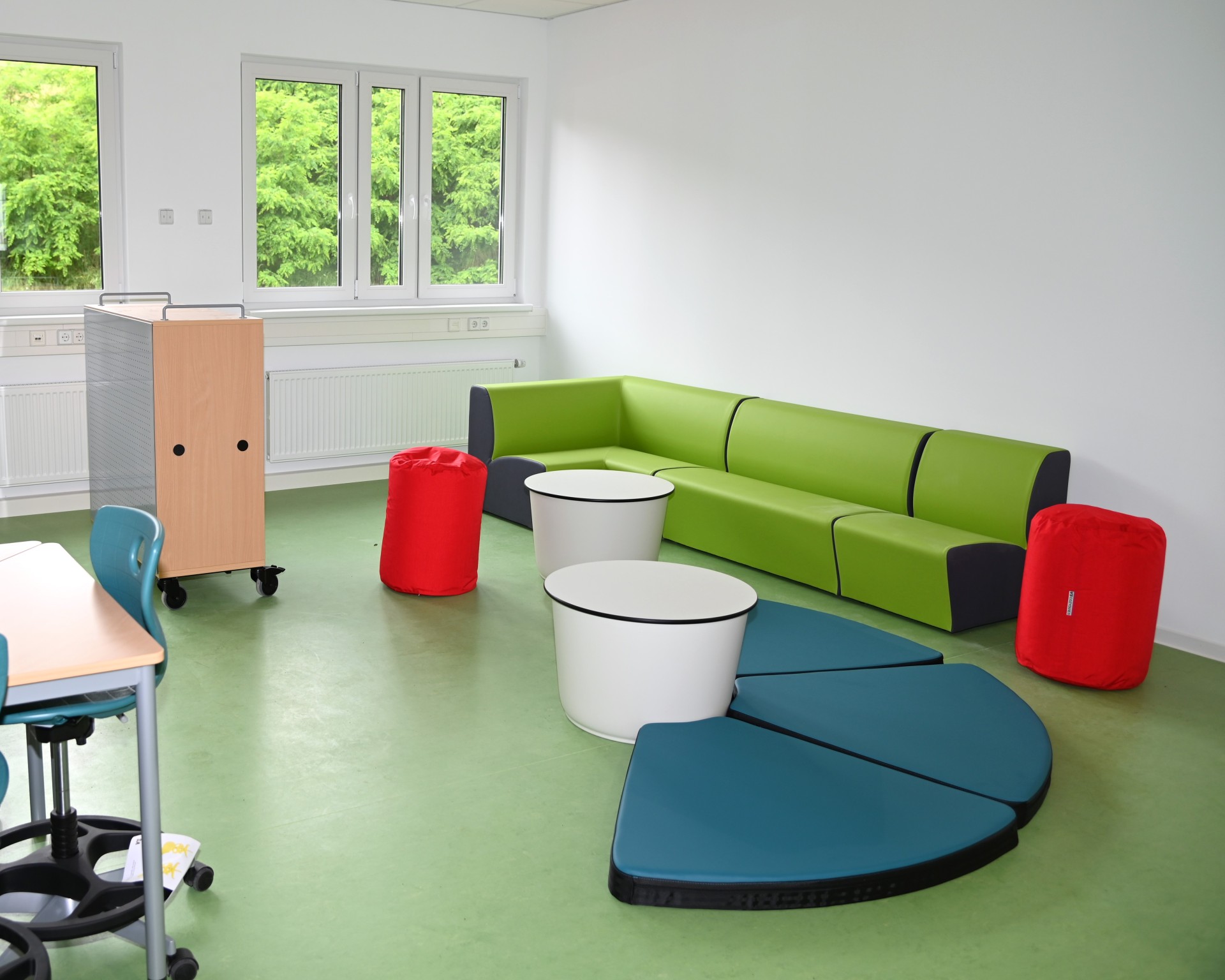 Das Bild zeigt einen Raum mit multifunktionalem Mobiliar für die Schulkindbetreuung.
