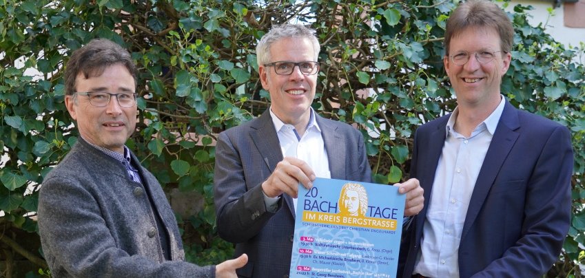 Landrat Christian Engelhardt hält mit dem Regionalkantor Gregor Knop und dem Leiter des Oratorienchors Bergstraße, Christian Mause das Programm der diesjährigen Bachtage in den Händen.