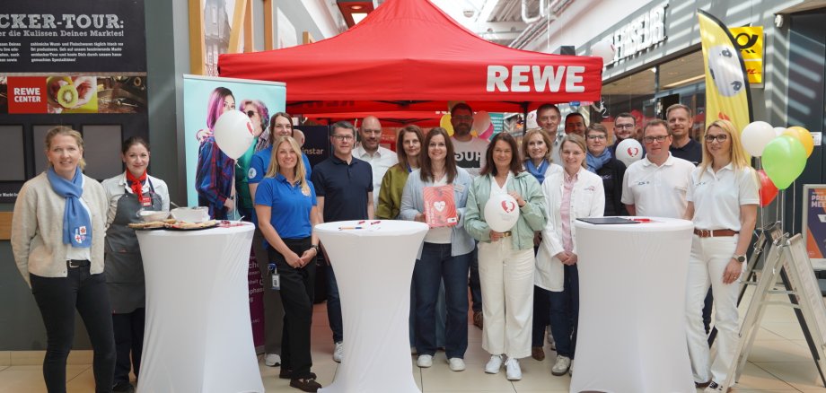 Der Aktionstag im REWE Center Heppenheim lieferte wichtige Informationen zur Gesundheit von Frauenherzen. Auf dem Bild sind alle Kooperationspartner zu sehen.