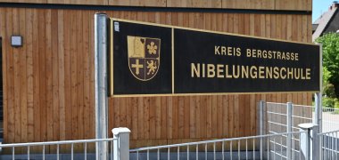 Neue Unterrichtsmodule Das Schulschild vor einem der neuen Unterrichtsmodule.