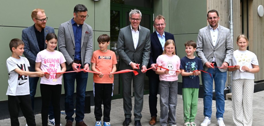 Eröffnung Der technische Betriebsleiter des Eigenbetriebs Schule und Gebäudewirtschaft, Johannes Kühn, Schulleiter, Markus Taube, Landrat Christian Engelhardt, Bürgermeister Matthias Baaß und der Erste Stadtrat Jörg Scheidel scheiden mit den Schülerinnen und Schülern der Friedrich-Fröbel-Schule Viernheim das rote Band durch.