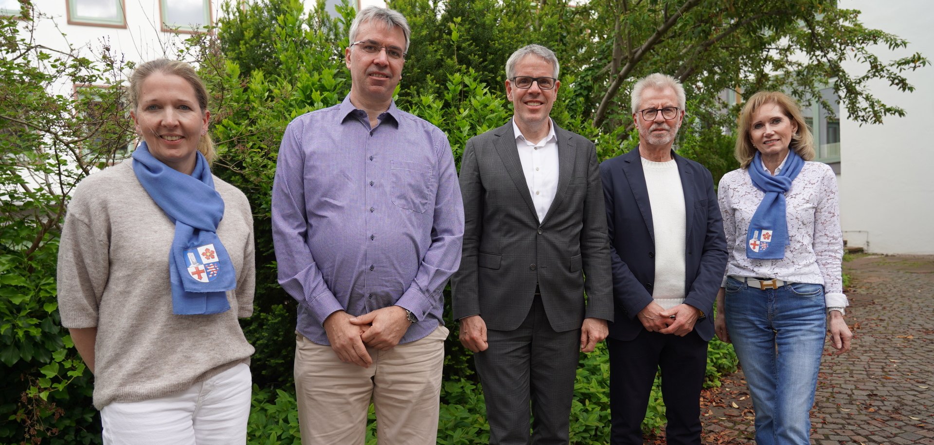 Landrat Christian Engelhardt steht gemeinsam mit Nadja Niestroj und Reinhild Zolg vom Präventionsteam des Kreises Bergstraße, dem Facharzt für Hals-Nasen-Ohrenheilkunde und Allergologe, Dr. Wolfram Hess, sowie dem Apotheker Wolfgang Kempf im Innenhof des Landratsamts.