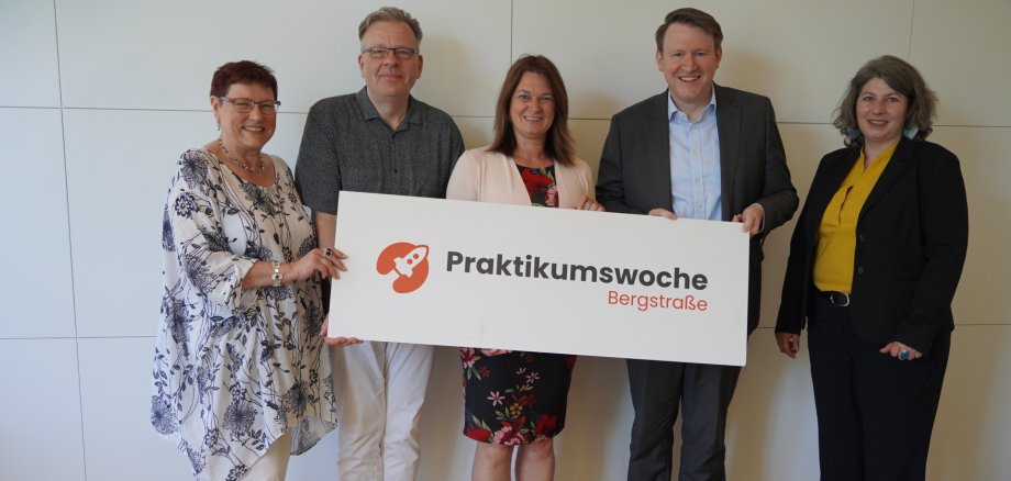 Karin Weißhaar (OloV-Regionalkoordination, Neue Wege Kreis Bergstraße -Kommunales Jobcenter-), Hermann Riebel (OloV-Regionalkoordination, Jugendamt Kreis Bergstraße), Angelika Beckenbach (Erste Kreisbeigeordnete, Kreis Bergstraße), Dr. Matthias Zürker (Geschäftsführer Wirtschaftsförderung Bergstraße GmbH) und Brigitte Stein-Kaucher (Projektmanagerin Unternehmens- und Gründungsservice, Wirtschaftsförderung Bergstraße GmbH) halten gemeinsam ein Schild zur Praktikumswoche.