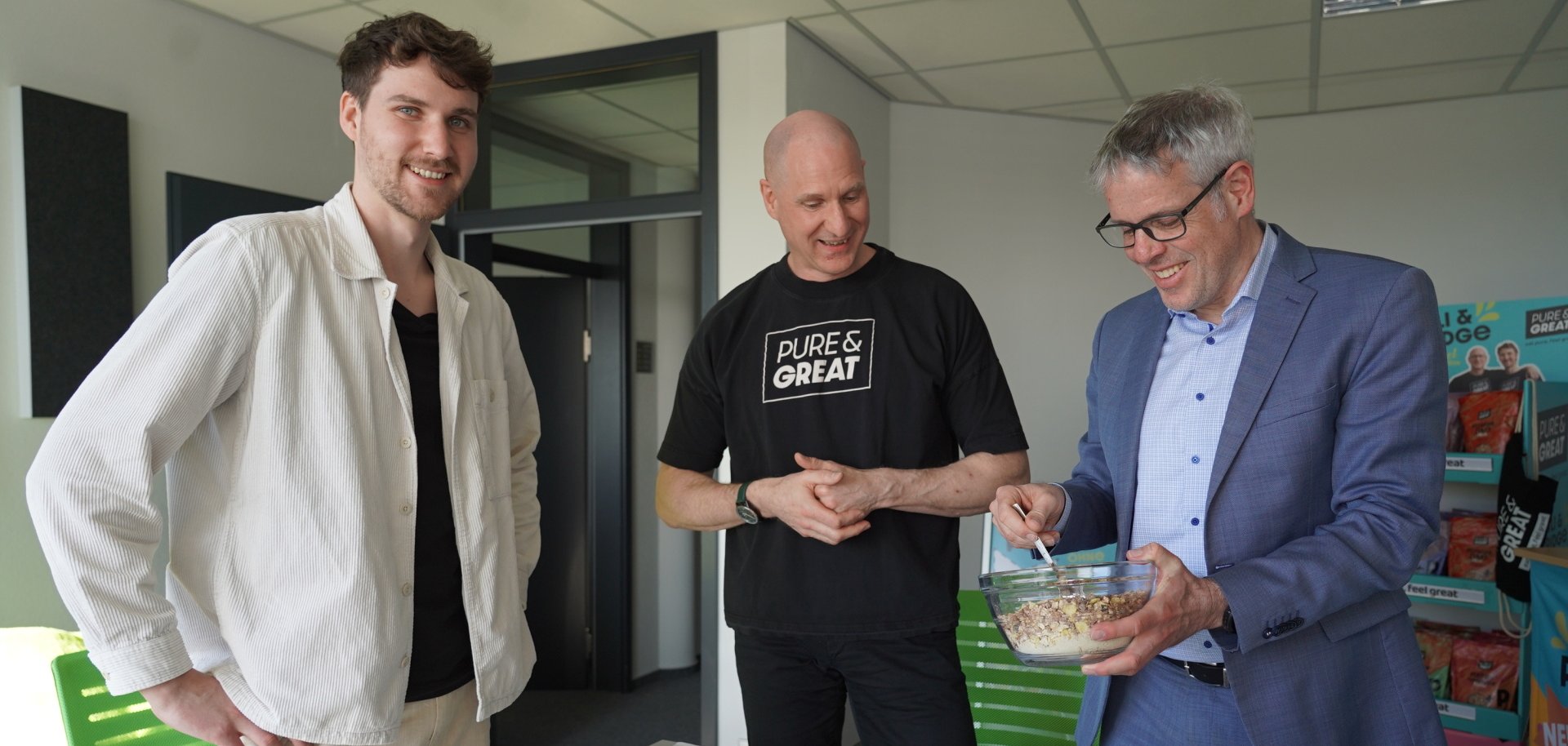 Daniel Margraf und Thomas Angotti zeigen Landrat Engelhardt, wie ihre Müslimarke begonnen hat.