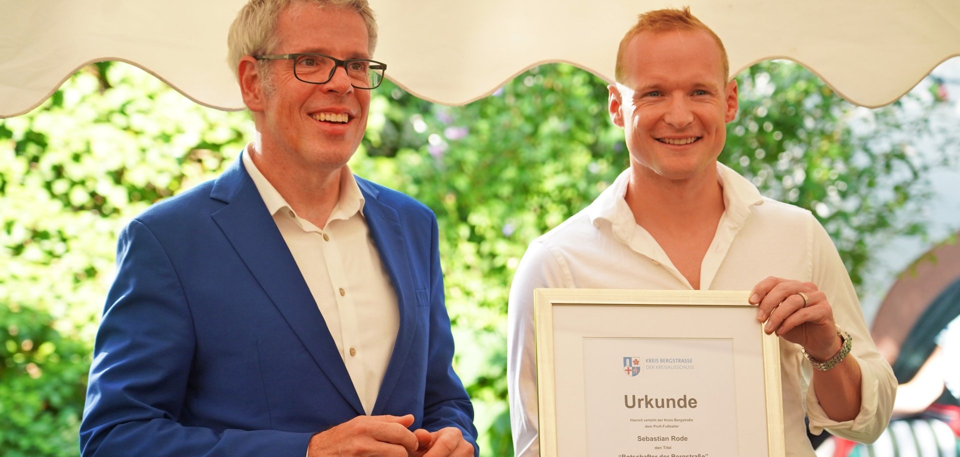Landrat Engelhardt überreicht Sebastian Rode die Ernennungsurkunde zum Botschafter der Bergstraße.
