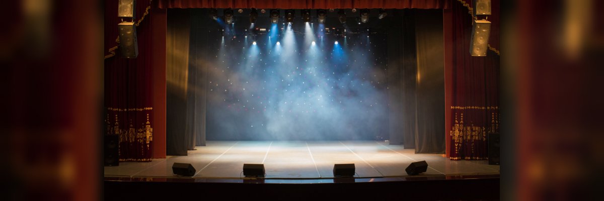 The stage of the theater illuminated by spotlights from the auditorium
