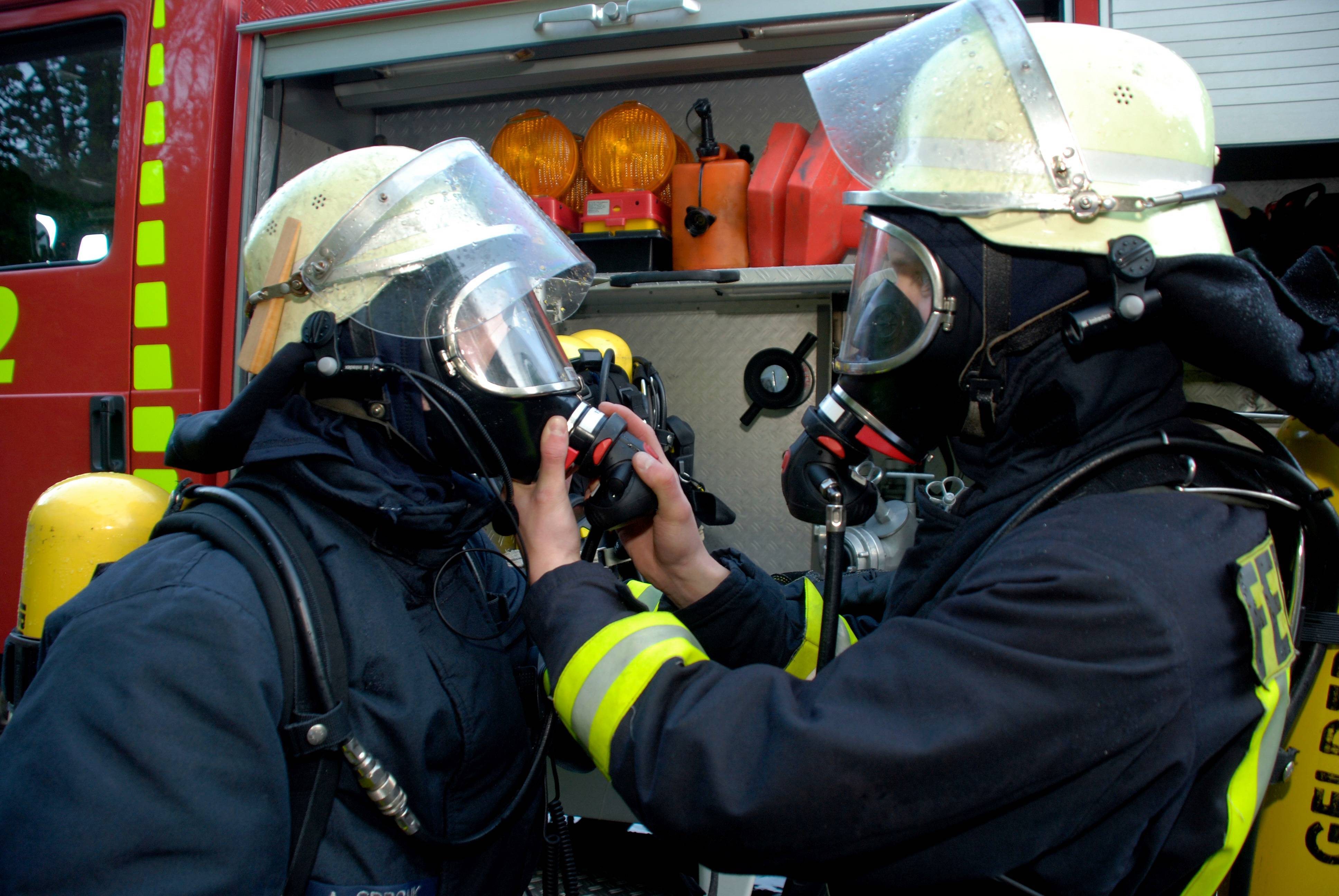 Auf dem Bild sind zwei Feuerwehrmänner mit Atemschutzgeräten zu sehen.