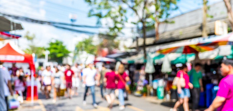 Blurred background : people shopping at market fair in sunny day
