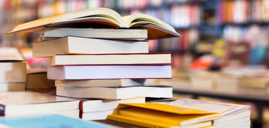 Ein Stapel Bücher liegt auf einem Tisch in einer Bücherhandlung.