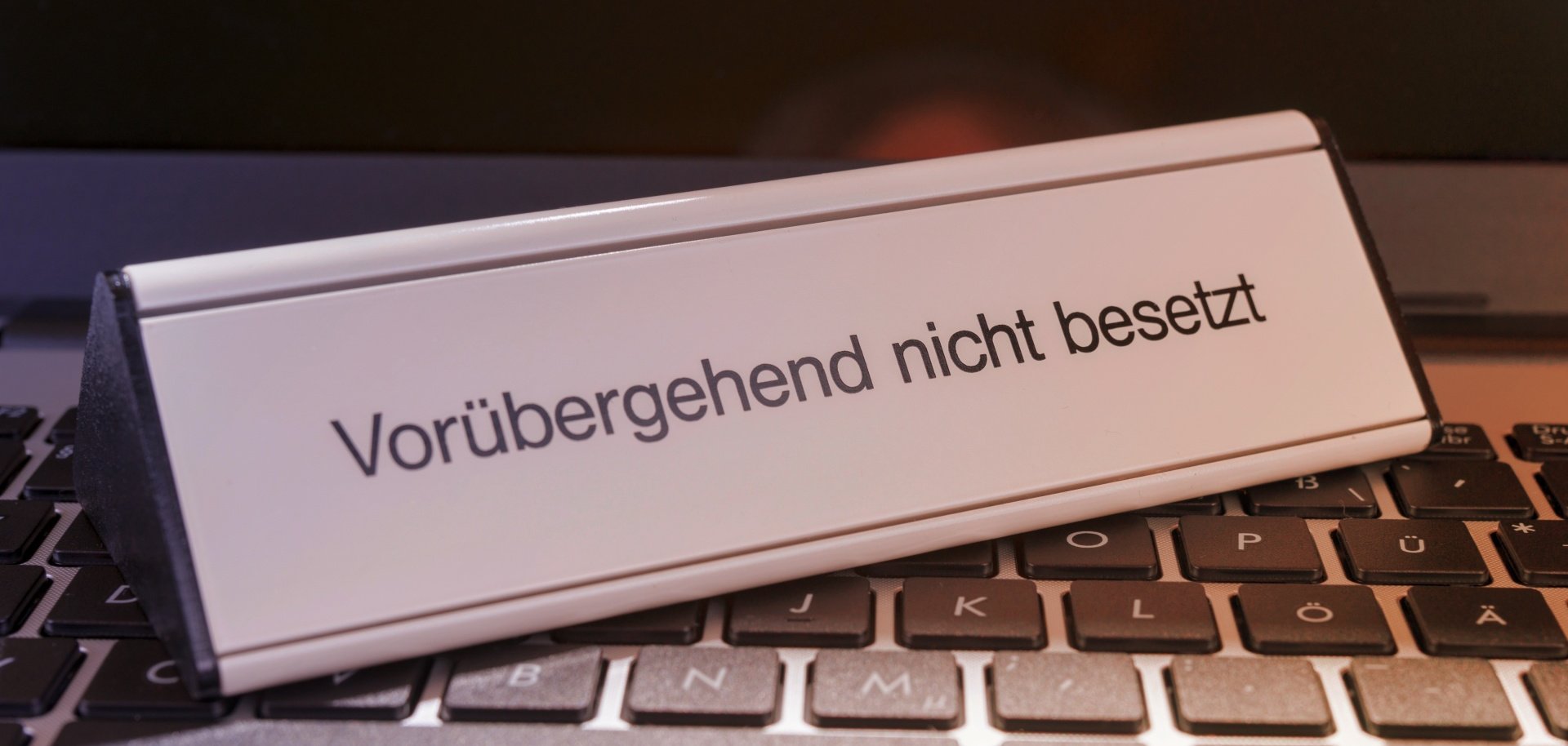 Ein Schild, auf dem "Vorrübergehend nicht besetzt" steht, steht auf einer Computer-Tastatur.
