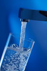 Glas wird mit Wasser befüllt