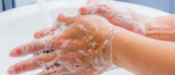 Jemand schäumt seine Hände mit Seife ein